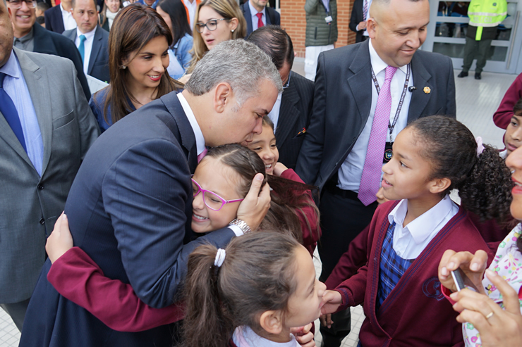 Foto de la Ministra María Victoria Angulo y el presidente Duque invitando a los niños a ingresar al colegio