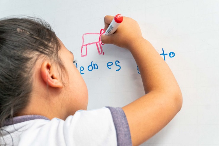 Niño escribiendo en tablero promoviendo matrículas 2023