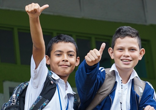 Estudiantes de colegio con las manos arriba
