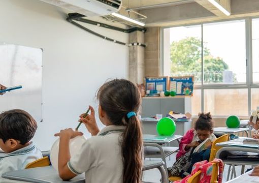 Profesora enseñando a estudiantes dentro del aula de clase