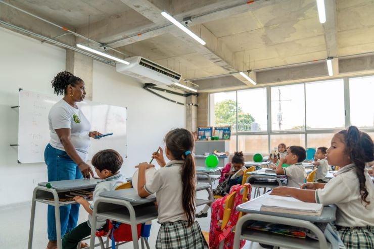 Profesora enseñando a estudiantes dentro del aula de clase Profesora enseñando a estudiantes dentro del aula de clase