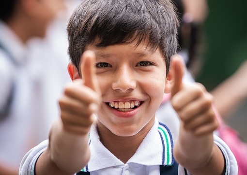 Estudiante de colegio con los dos pulgares arriba