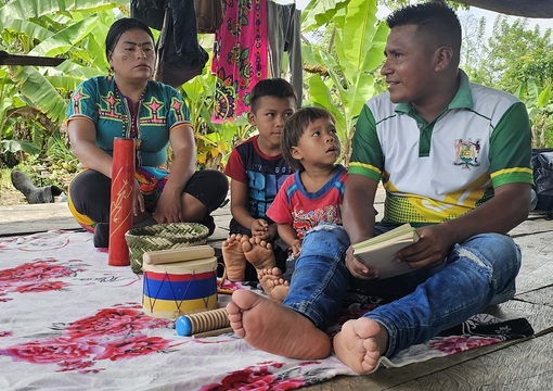 Profesor de primera infancia en tambo indigena enseñando clases a niños y niñas