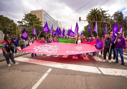 Grupo de personas trabajadoras con banderas del Ministerio de Educación Nacional en una marcha en Bogotá