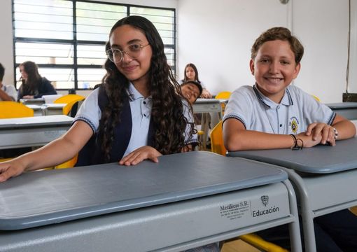 Dos estudiantes, niña y niño, dentro del aula de clase