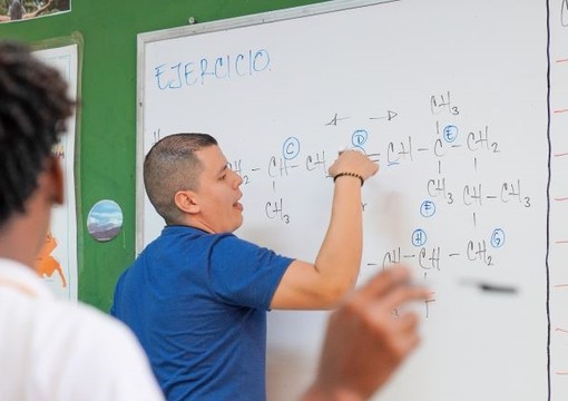 Docente frente a un tablero en clase