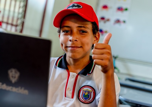 Niño con computador sonriendo
