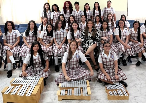 niñas de colegio posando con profesoras e instrumentos