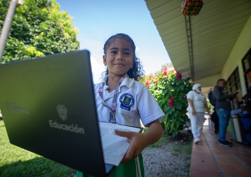 Niña sonriendo con un computador