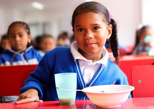 Niña disfrutando de un plato de comida del pae