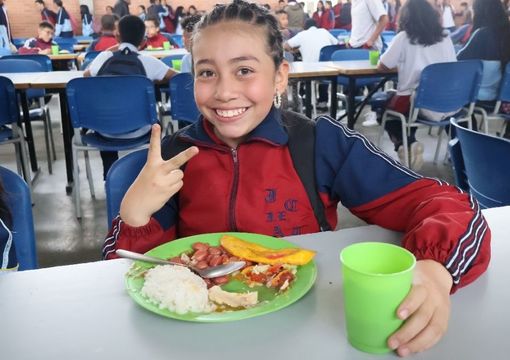 Niña sonriente en comedor escolar