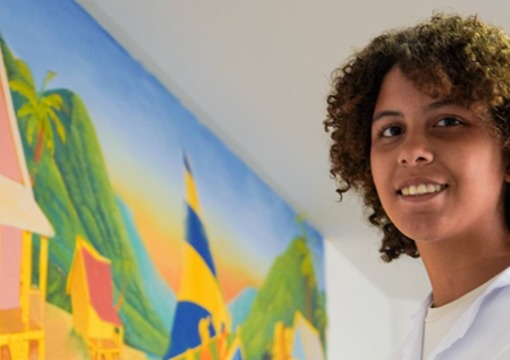 Joven pintando un mural del Ministerio de Educación Nacional