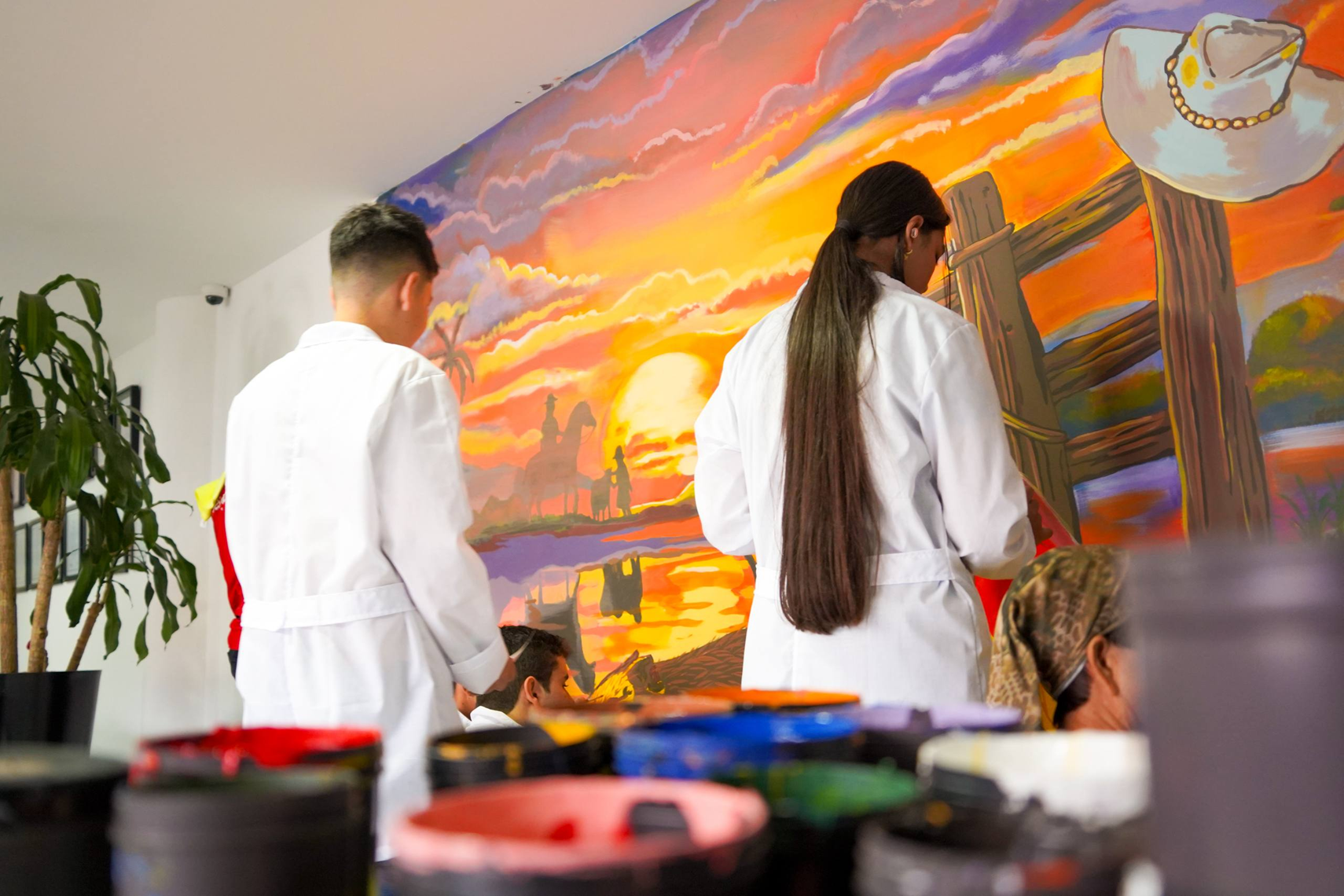 Jóvenes pintando un mural del Ministerio de Educación Nacional