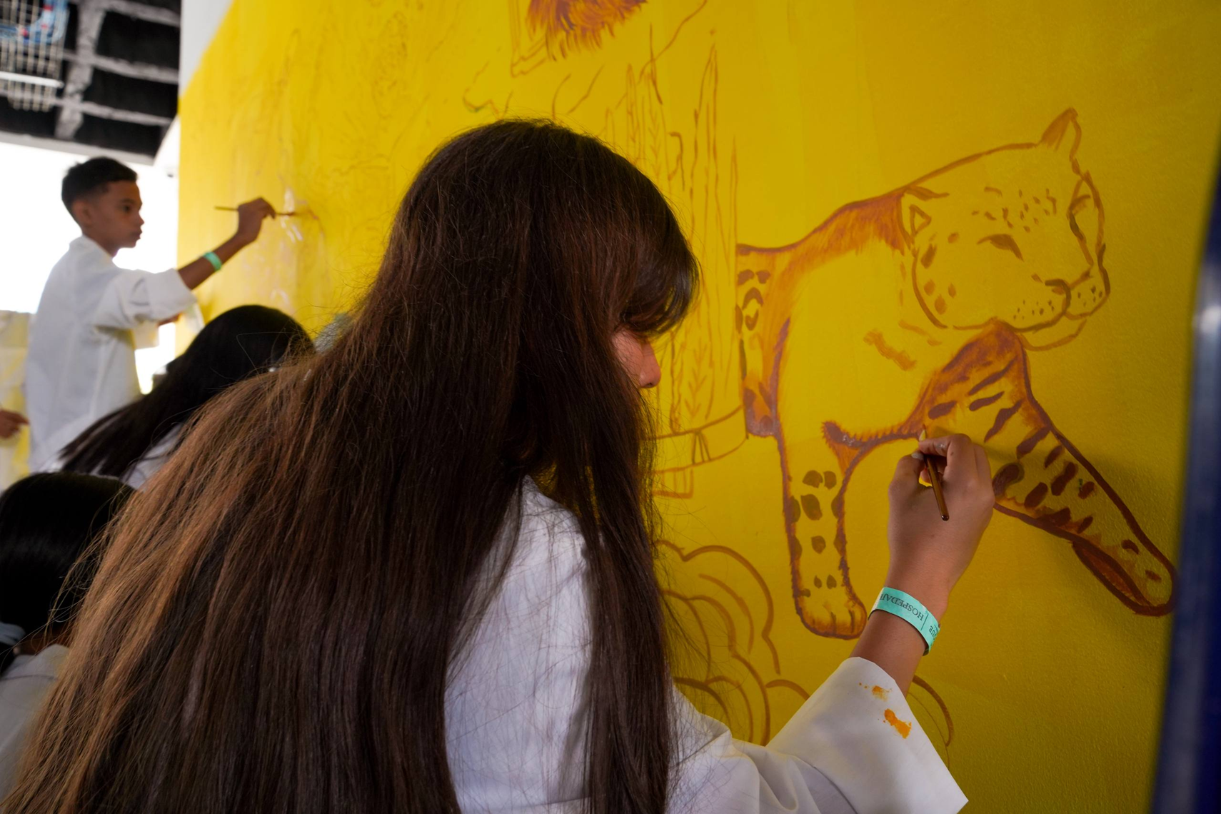 Jóvenes pintando un mural del Ministerio de Educación Nacional