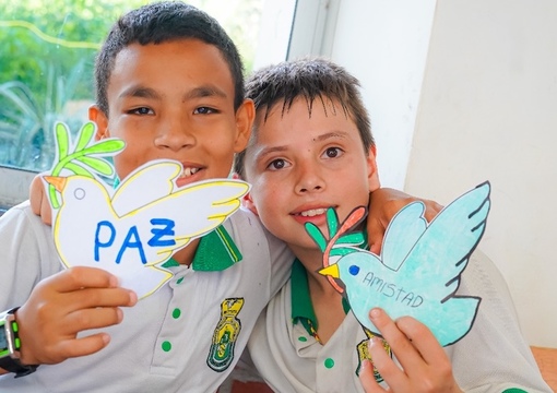 Fotos de niños en convivencia abrazados con un mensaje de paz