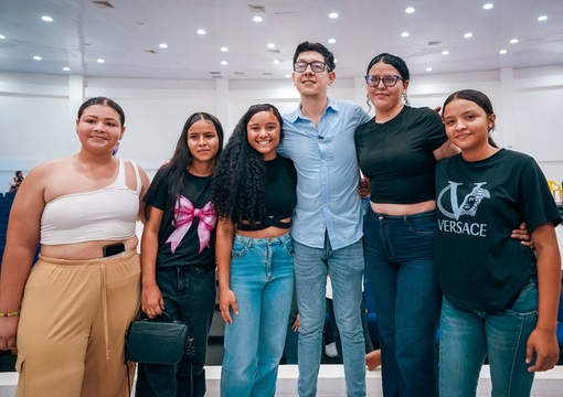 Ministro de Educación Daniel Rojas con cuatro estudiantes sonriendo