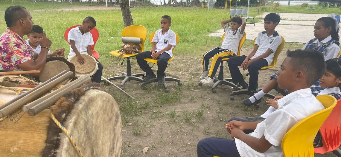foto de profesor con estudiantes aprendiendo de musica