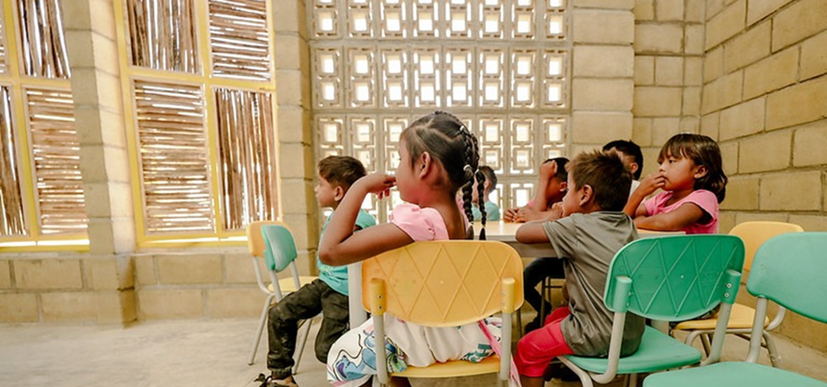 Niños sentados alrededor de un pupitre