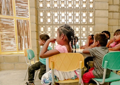 Niños sentados alrededor de un pupitre