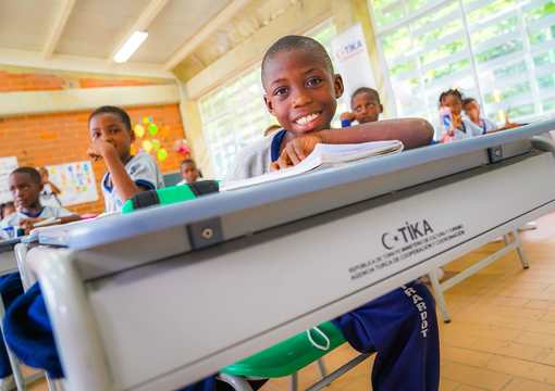 foto en salon de clase de estudiante sonriendo