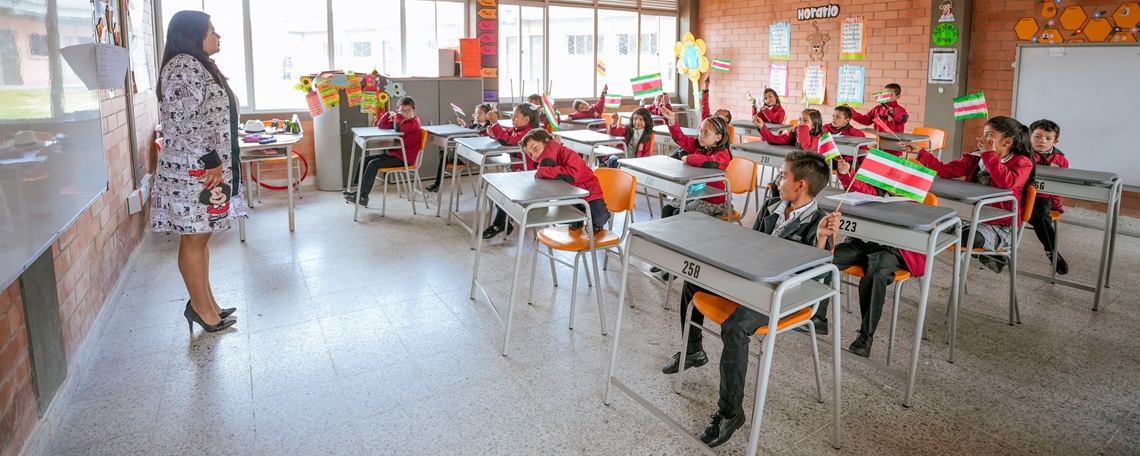 Foto de salon de clases con profesora y estudiantes