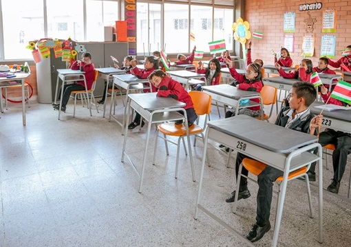 Foto de salon de clases con profesora y estudiantes