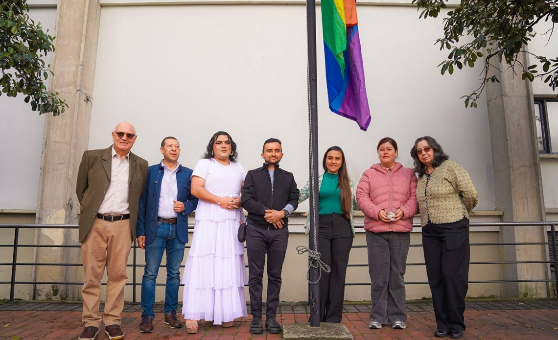 Personas del Ministerio de Educación con la bandera del orgullo gay
