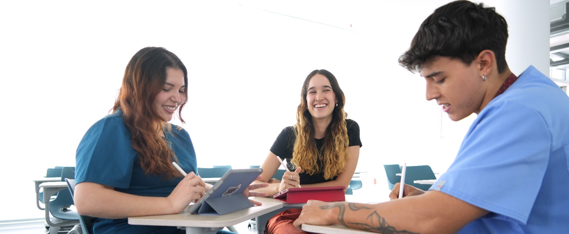 Tres estudiantes jóvenes en un salón de clases