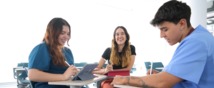 Tres estudiantes jóvenes en un salón de clases