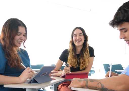 Tres estudiantes jóvenes en un salón de clases