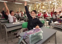 Niños de la IE Enrique Vélez de Itagüí levantando la mano en salón de clases